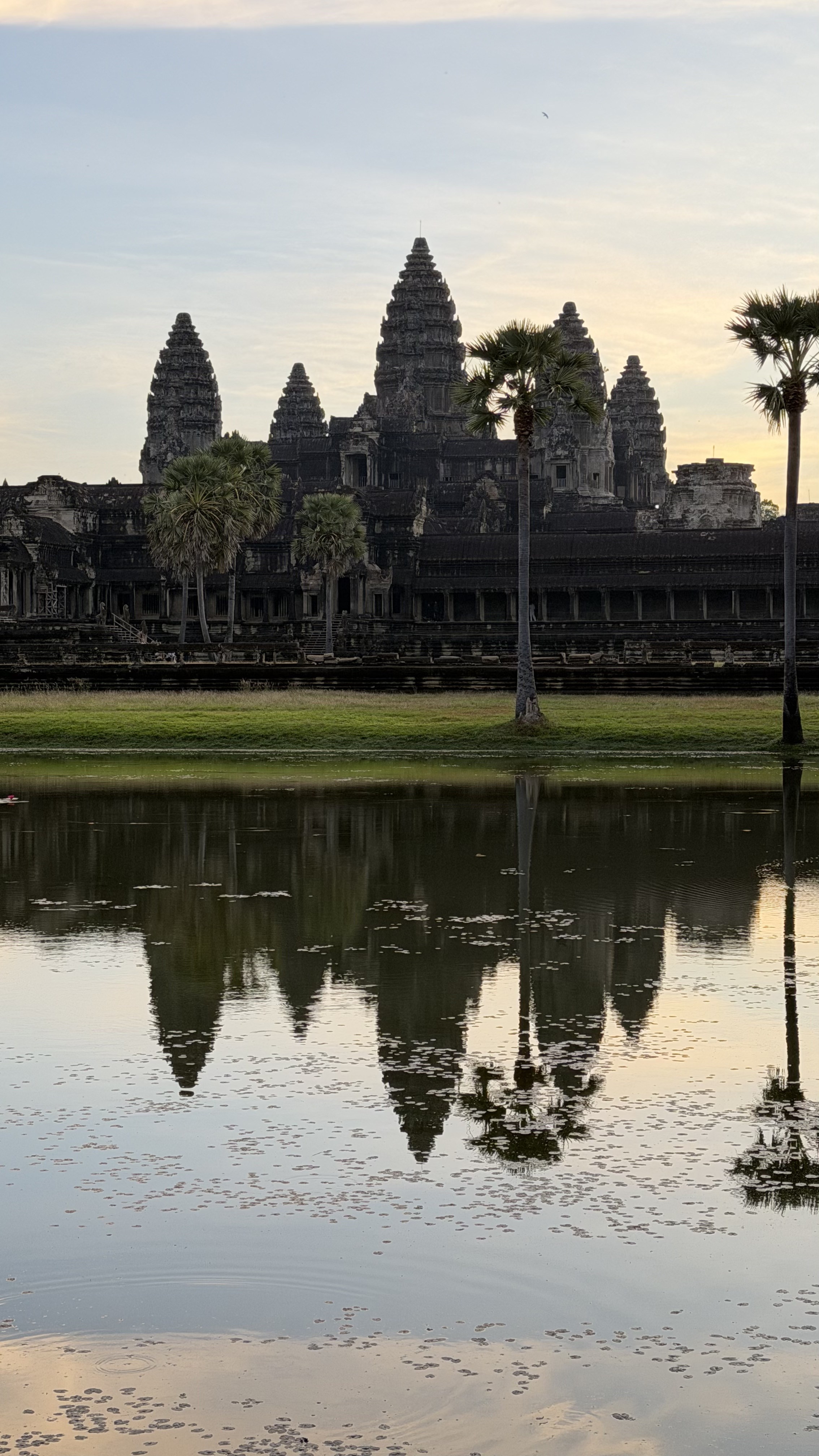 Angkor Wat temple reflected in the water at sunrise