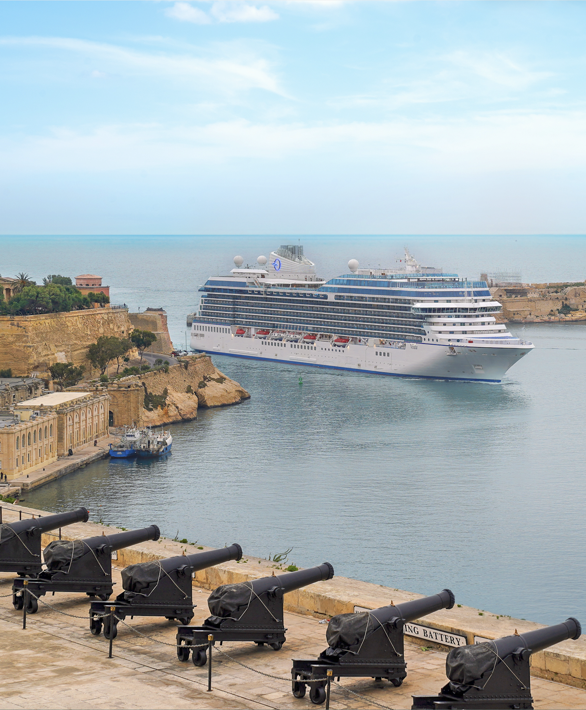 Oceania cruise ship sailing past historic fortifications in Valletta, Malta