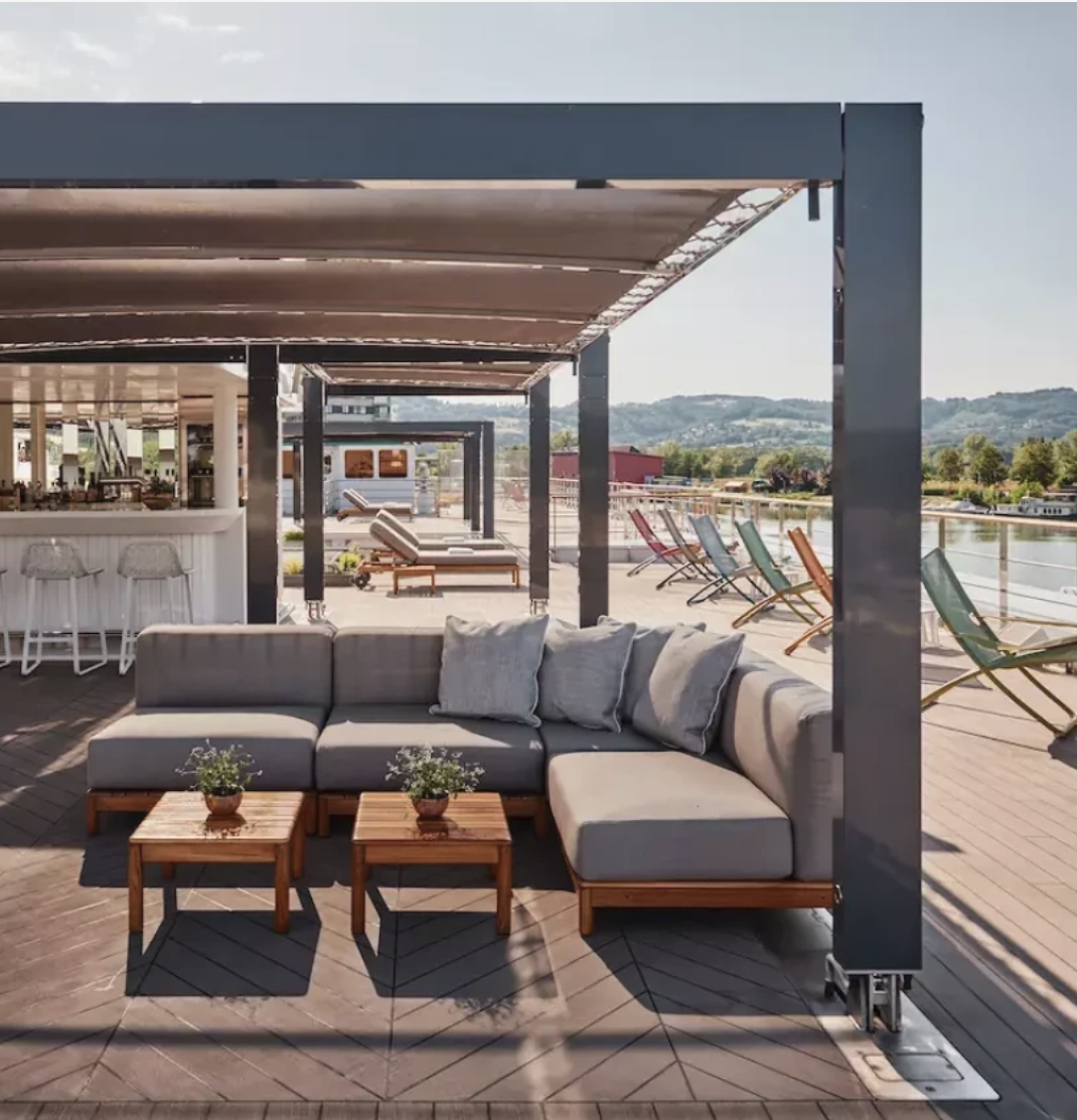 Riverside Luxury Cruises ship deck with lounge seating beside the river
