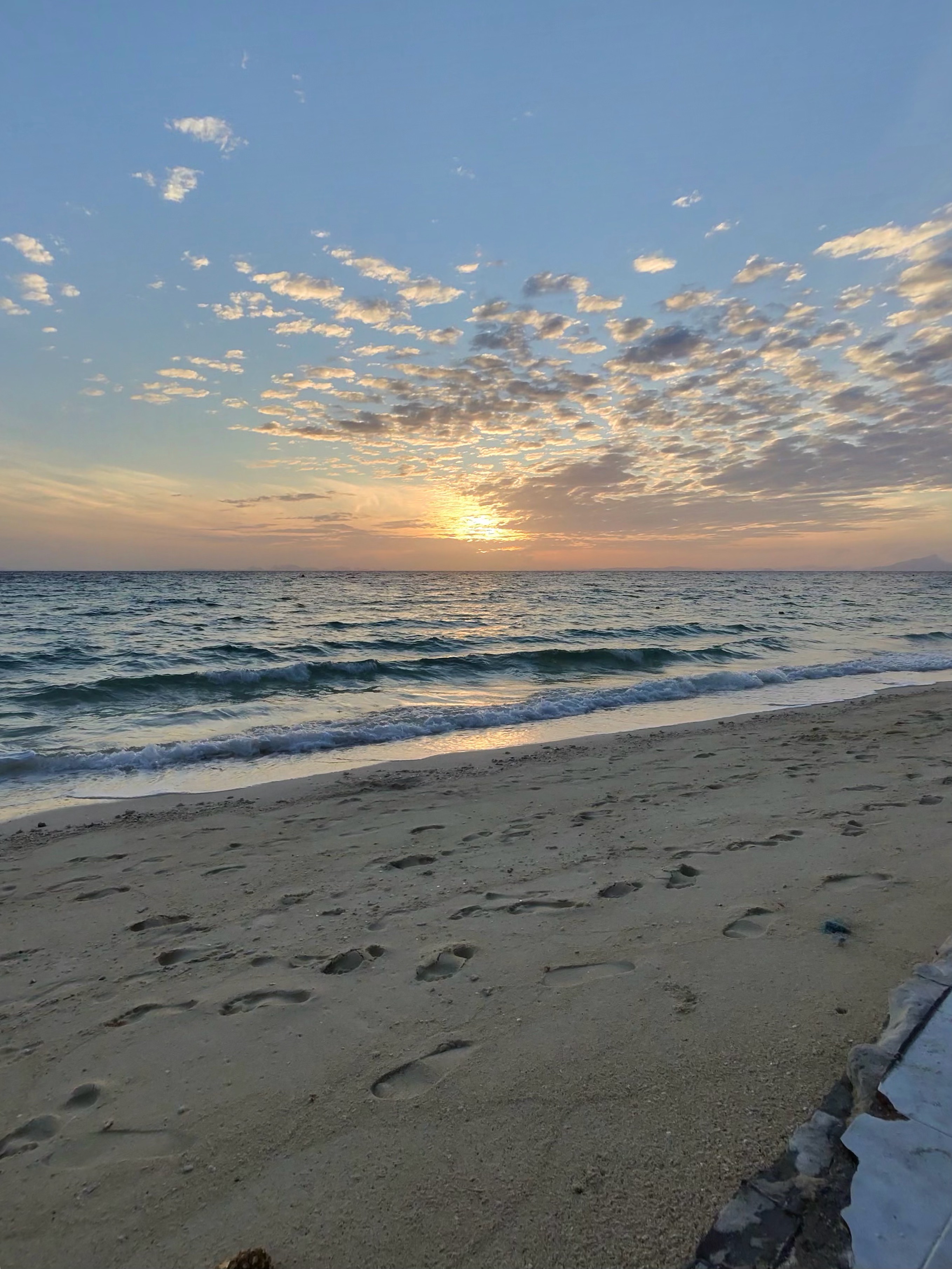 Sunset over the sea from a sandy beach